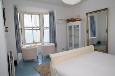 a bedroom with a bed and a mirror at Trem y Don New Quay in New Quay