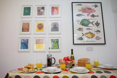 a table with plates of food and a bottle of wine at Trem y Don New Quay in New Quay