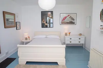 a bedroom with a white bed and two night stands at Trem y Don New Quay in New Quay