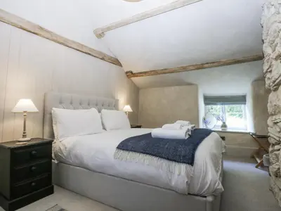 a bedroom with a large bed with a blue blanket at Islwyn in Bala