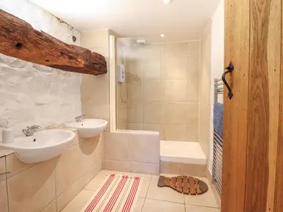 a bathroom with a sink and a toilet and a shower at Ty Newydd Uchaf in Dolgellau