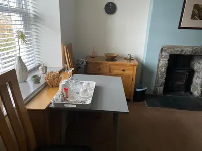 a room with a table with dishes on it with a fireplace at Garth Engan B&B with private lounge in Llanbedr