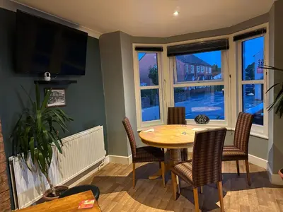 a dining room with a table and chairs and windows at The Boughton Peterchurch - Pub Grub & Bed in Peterchurch