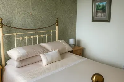 a bed with white pillows on it in a bedroom at The Boughton Peterchurch - Pub Grub & Bed in Peterchurch