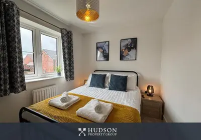 a bedroom with a bed with two towels on it at 3 Bedroom Modern Property with Parking in Shrewsbury