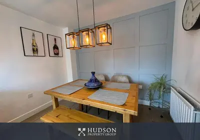 a dining room table with a vase on top of it at 3 Bedroom Modern Property with Parking in Shrewsbury