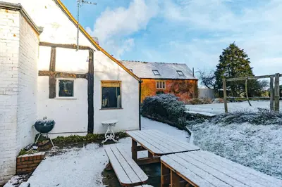 a picnic table and bench outside of a building at RYTON GRANGE FARMHOUSE to sleep 12 in Shrewsbury