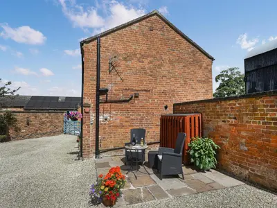 a brick building with two chairs and a table at Lavender Cottage in Shrewsbury