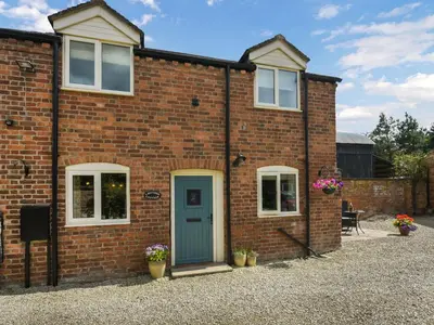 a brick house with a blue door at Lavender Cottage in Shrewsbury