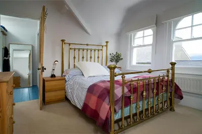 a bedroom with a bed and two windows at Morwylfa Borth and Ynyslas in Borth