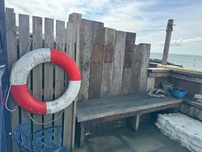 a wooden bench with a red ring attached to a wooden fence at Morwylfa Borth and Ynyslas in Borth