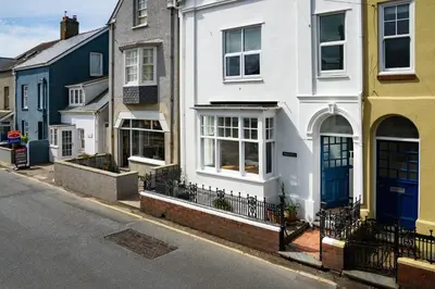 a white house with a blue door on a street at Morwylfa Borth and Ynyslas in Borth
