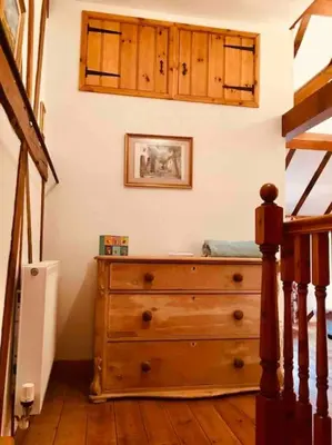 a bedroom with a wooden dresser in a room at Tawny Owl Barn in Leintwardine