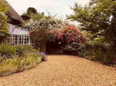 a garden with flowers and trees and a building at Tawny Owl Barn in Leintwardine