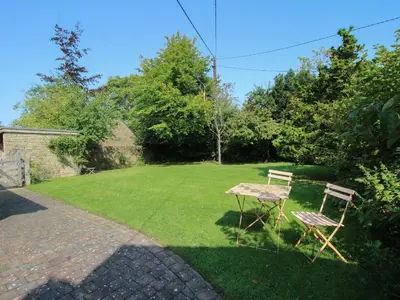 a table and two chairs sitting in a yard at New Inn Cottage in Church Stretton