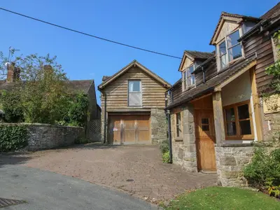 a wooden house with a garage and a driveway at New Inn Cottage in Church Stretton