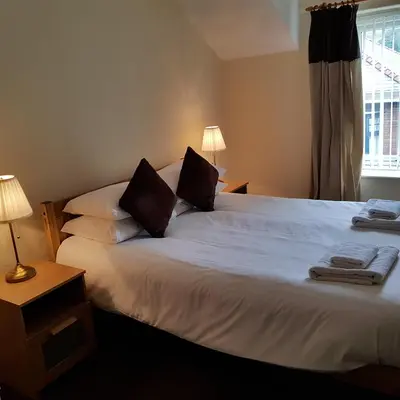 a bedroom with a large white bed with two pillows at Ty Morgan's Apartments in Rhayader
