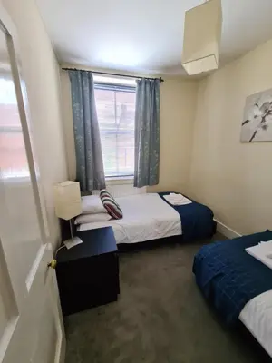 a small room with two beds and a window at Ty Morgan's Apartments in Rhayader