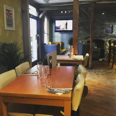 a dining room with tables and chairs and a television at Ty Morgan's Apartments in Rhayader