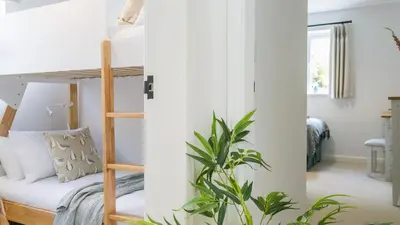 a bedroom with bunk beds and a plant at Swn y Mor in Harlech