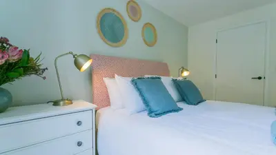a bedroom with a white bed with blue pillows at Swn y Mor in Harlech