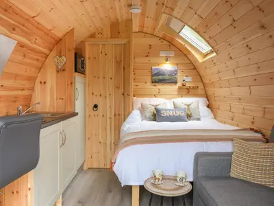 a bedroom with a bed in a wooden cabin at Caban Tirion in Machynlleth