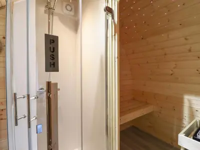 a wooden sauna with a sign on the wall at Caban Tirion in Machynlleth