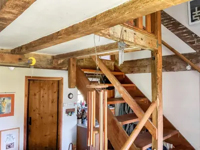 a loft bed in a room with wooden beams at Cwmberwyn in Llansaintfraed in Elvel