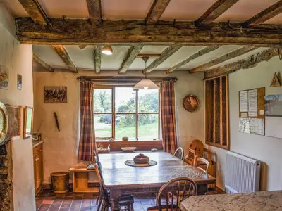 a dining room with a table and a large window at Cwmberwyn in Llansaintfraed in Elvel