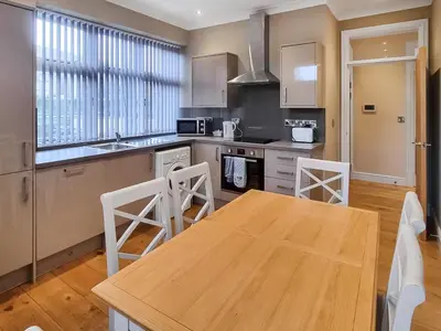 a kitchen with a wooden table and chairs in it at Uk47787 - Flat 5E in Aberystwyth