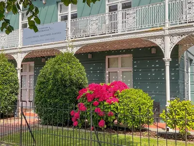 a building with pink flowers in front of a fence at Flat 3E - Uk47858 in Aberystwyth