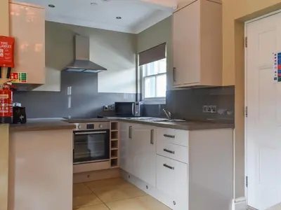 a kitchen with white cabinets and a window at Flat 3E - Uk47858 in Aberystwyth