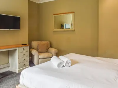 a bedroom with a bed and a chair and a television at Flat 3E - Uk47858 in Aberystwyth