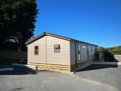 a small house is sitting in a parking lot at Mountain View Brown lodge in Aberystwyth