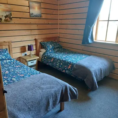 a room with two beds in a log cabin at Owl Cabin in Llanbrynmair