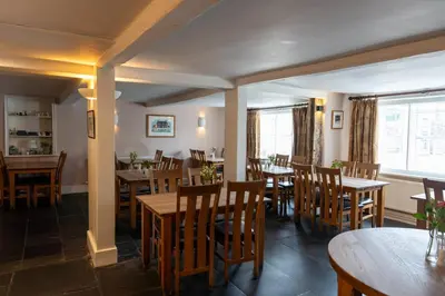 a dining room with wooden tables and chairs at Glan Yr Afon in Pennal