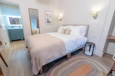 a bedroom with a white bed with a rug at Glan Yr Afon in Pennal