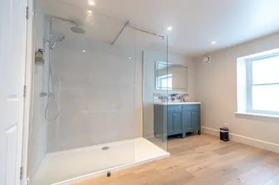 a bathroom with a shower with a glass door at Glan Yr Afon in Pennal