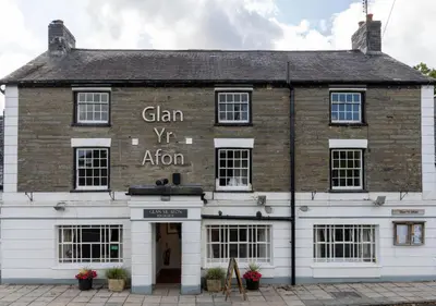 an old brick building with the sign for gin vs algorithm at Glan Yr Afon in Pennal