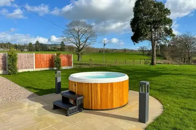 a large wooden tub with a grill in a park at Marrington Lodge in Chirbury