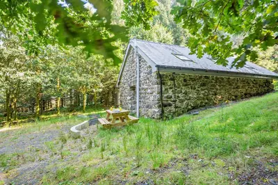 a stone building with a picnic table in front of it at 1 Bed in Brithdir oc-w30045 in Rhydymain