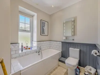 a bathroom with a bath tub and a toilet at Pencartref- Luxurious Seaside Apartment Aberdovey in Aberdyfi