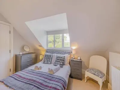 a bedroom with a large bed and a window at Pencartref- Luxurious Seaside Apartment Aberdovey in Aberdyfi