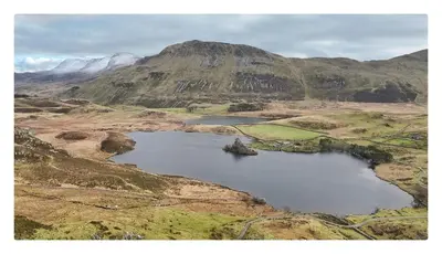 an aerial view of a lake in the mountains at Y Mor Cosy Apartment in Tywyn