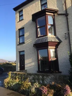 a building with windows on the side of it at Y Mor Cosy Apartment in Tywyn