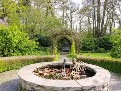 a garden with a fountain with a man in it at Trem-Yr-Afon in Lampeter