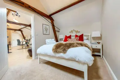 a bedroom with a white bed with red pillows at The Annexe in Chirbury