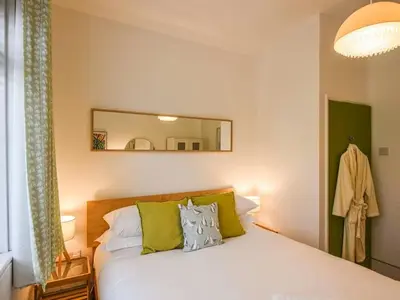 a bedroom with a bed with a mirror on the wall at The Glass House in Aberdyfi