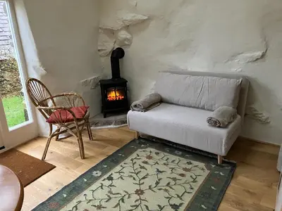 a living room with a couch and a fireplace at Studio in medieval Welsh farmhouse in Aber Cowarch