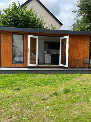 a small house with a patio and a table at Ty Sycamore in Talybont